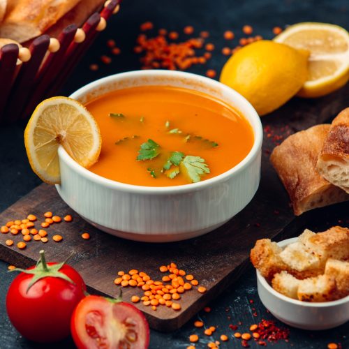 red lentil soup with a slice of lemon and breadcrumbs